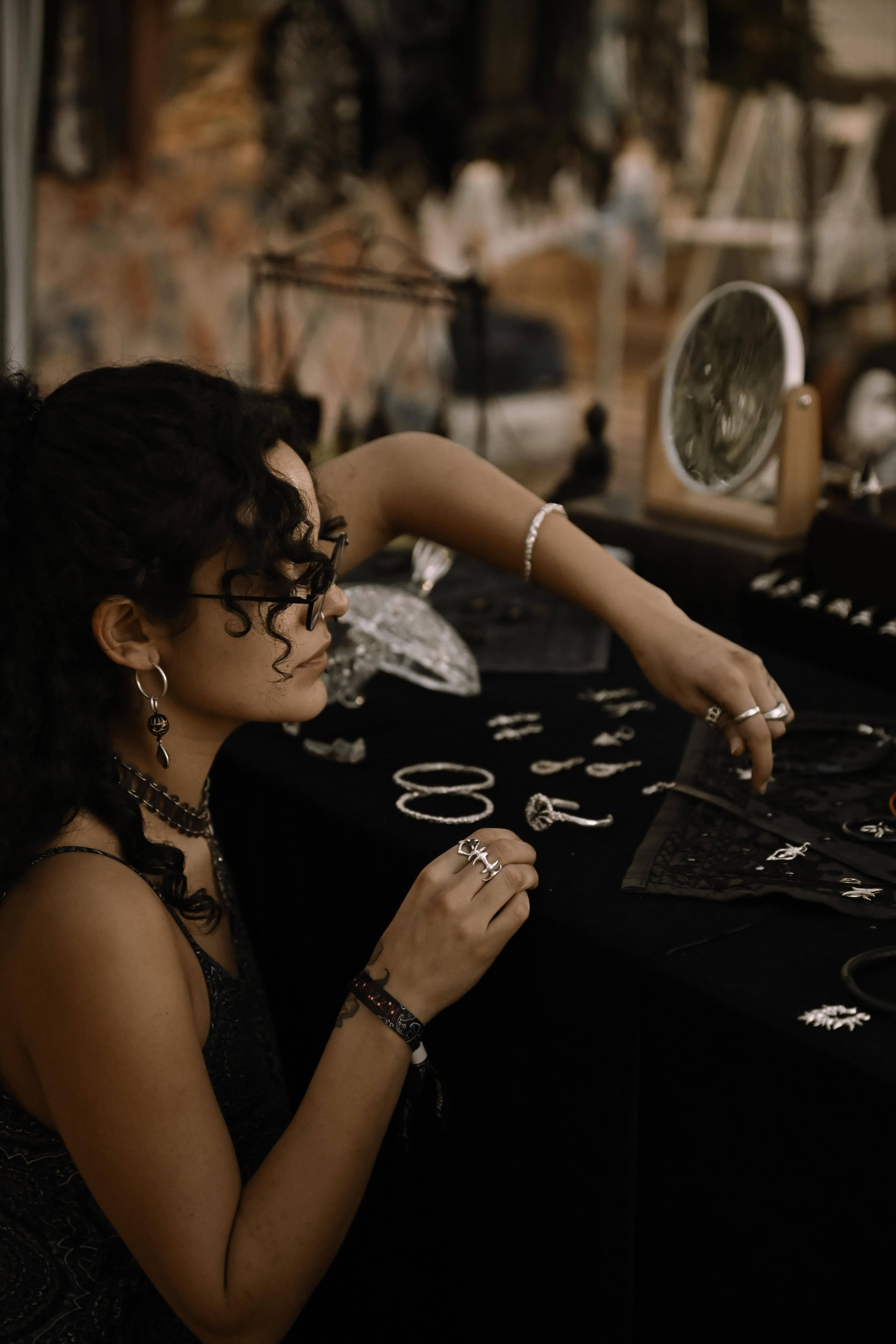 The maker laying out hand-forged silver at the stall
